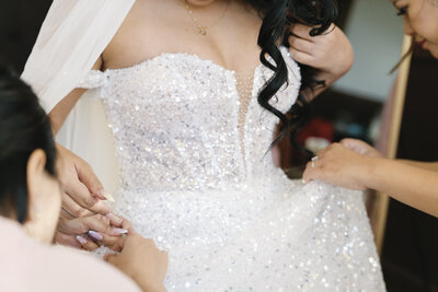 Bridesmaids Ensuring a Perfect Fit: Heartwarming Pre-Ceremony Moment as They Help Bride Put On Her Wedding Dress