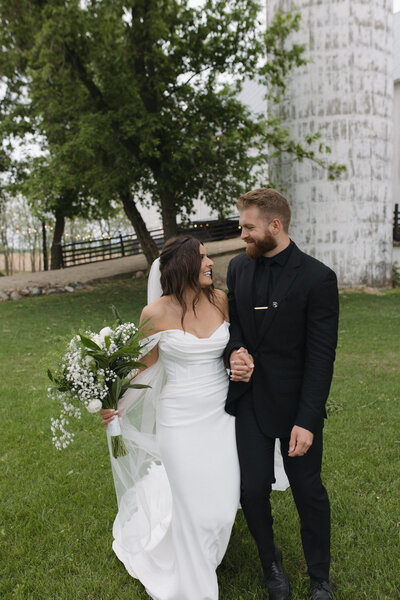 Bride and groom walk together during their portraits for their intimate wedding. Romantic shot capturing a soft, candid moment for couples planning a small wedding.