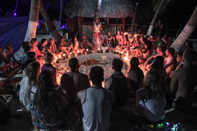 Noelle Rivet teaching meditation to a group of people at night during a festival in the San Blas Islands in Panama