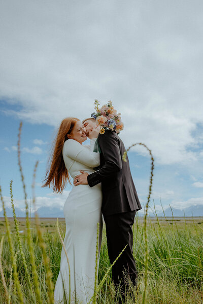 groom kissing bride on her cheek