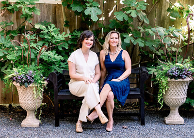 Container gardeners sitting on bench in front of espallier tree