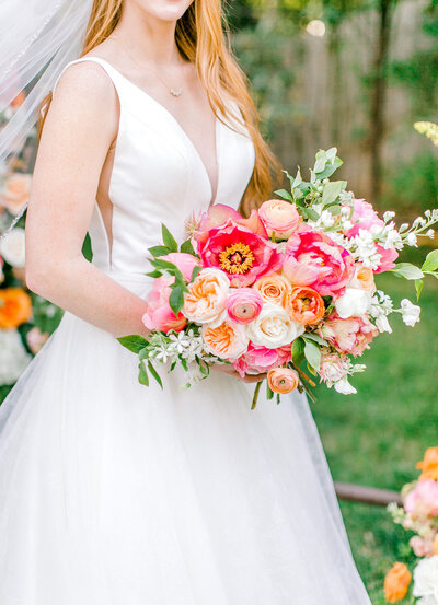 Bride holding a very pink and colorful bouquet