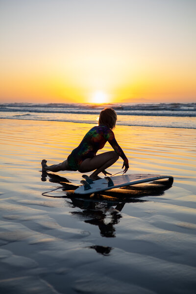 Surfer stretches before surfing at sunrise