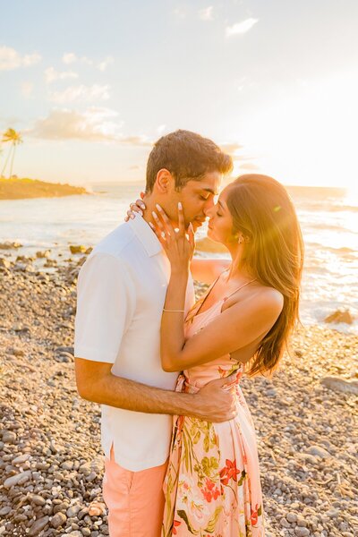 Young couple embraces on the beach in Maui during their couples photoshoot on the beach