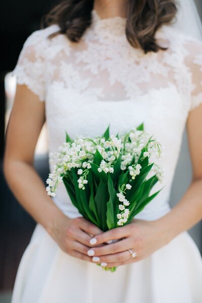 Bride holding a bouquet of white flowers.