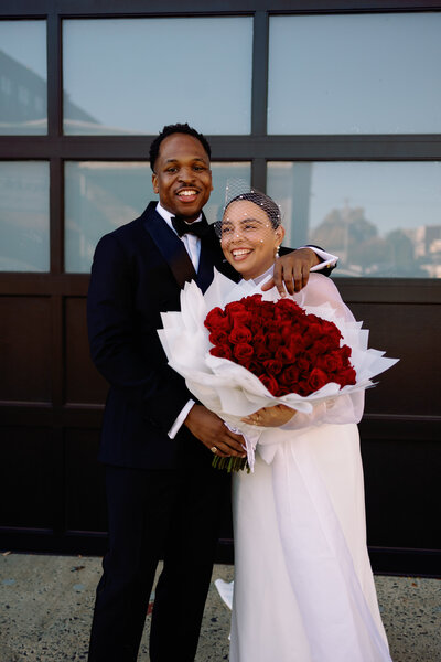 bride and groom with huge bouquet of red roses Philadelphia wedding