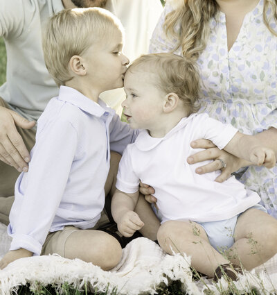 Young Family Outdoors Little Boy Kissing His Infant Brother