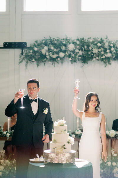 a bride and groom raising their Champagne glasses during a wedding reception