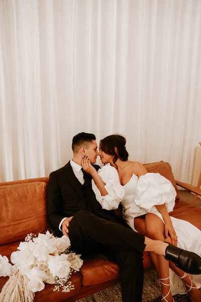 bride and groom sitting on the couch