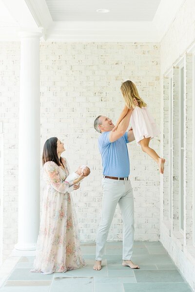 Minges family playful newborn outdoor photos with toddler girl sister and baby girl with parents in Greenville, North Carolina
