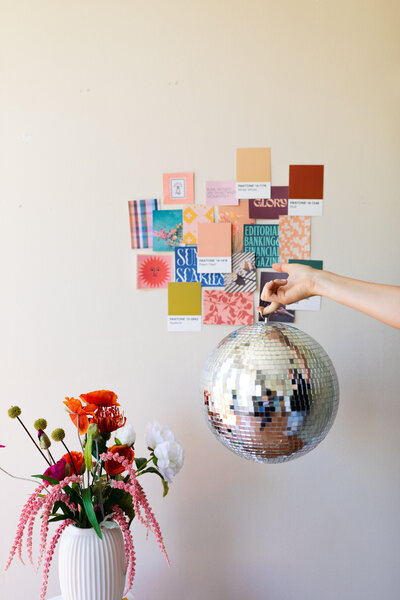 A colorful and feminine inspiration board and disco ball.