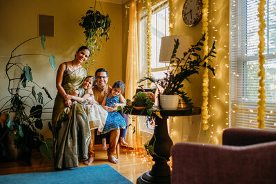 Family with young kids, cuddled together in indoor, relaxed, laughing family photo session in Akron, Ohio