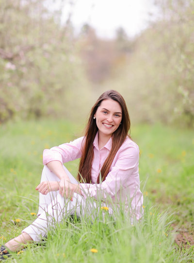 Girl sitting in grass smiling at camera
