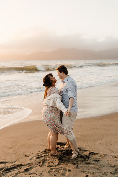 couple holding hands at baker beach