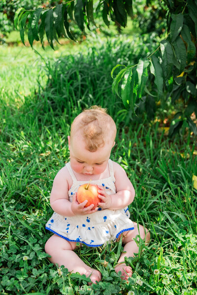 Baby holding a peach