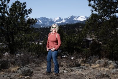 Jill P. Mott, photographer,  stands at the base of the Rocky Mountains in Colorado.