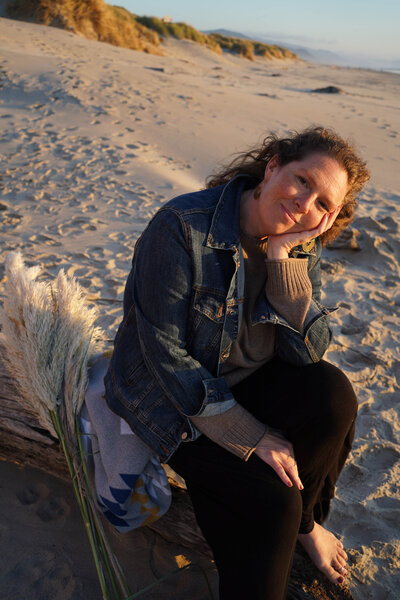 Smiling woman sitting on beach log