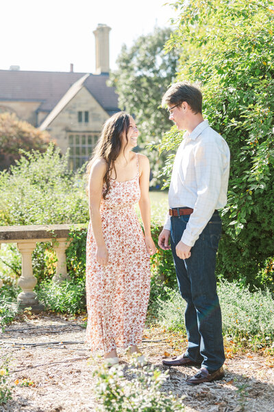 engaged couple walking in a garden