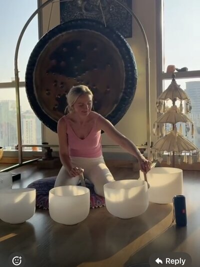 Women using sound bowls and a gong in the background