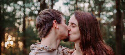 couple standing in woods engagement session