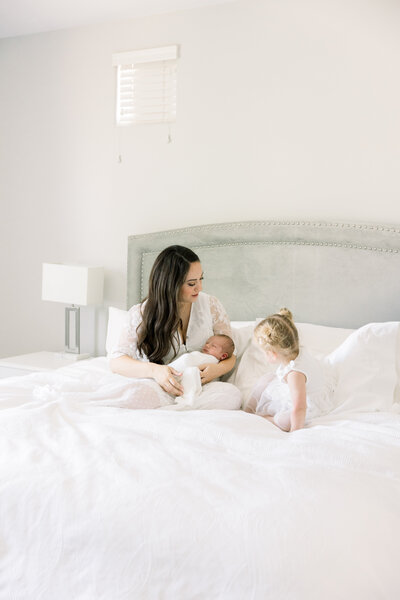 Image of sleeping baby wrapped in white with hands up taken by Newborn Photographer Sacramento Kelsey krall