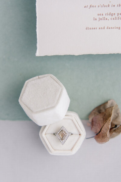 An engagement ring in a soft white box.
