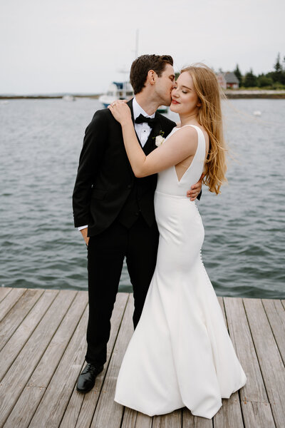 Groom kisses bride after first look on the water at Newagen Seaside Inn Boothbay Harbor, Maine