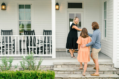 Round Top Hostie greeting guests on porch of Round Top Vacation Rental