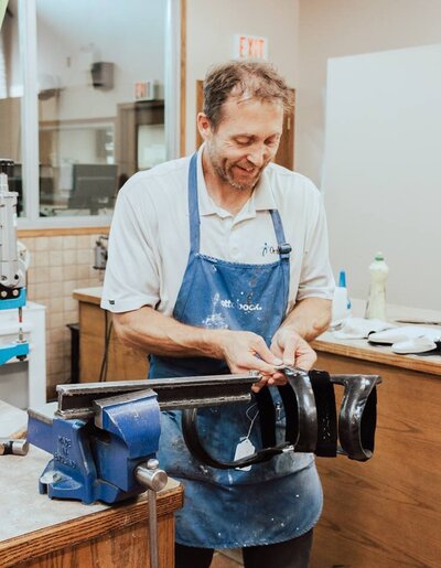 A skilled orthotics technician at the Lethbridge Orthotics carefully crafting prosthetic device for the amputees.