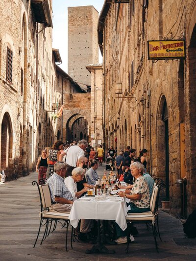 Travel group sharing a meal together in Italy