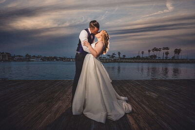 Bride and groom kissing at sunset at wedding in San Diego