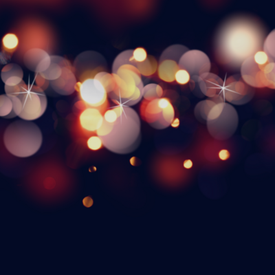 Black backdrop with warm-toned circular bokeh lights creating a firework-like effect.