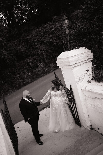 bride and groom standing next to gate