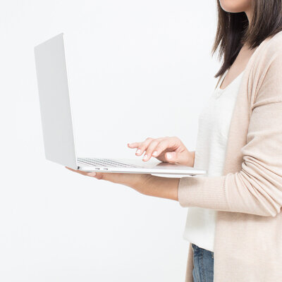 Girl holding Apple air laptop scrolling to a new webpage