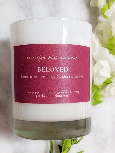 Beloved candle on marble background with white and green flowers