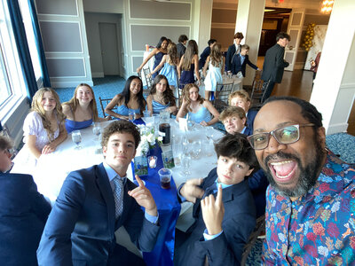 Teen students smiling and sitting at decorated tables before Chicago school dance with Charizma DJ services