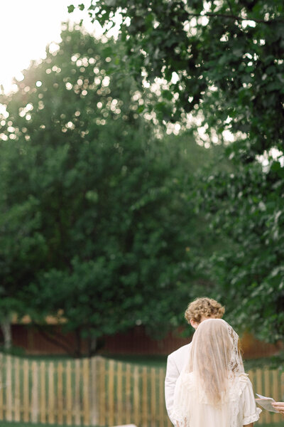 Peyton Curry and Jon exchanging vows during their backyard wedding ceremony in Richmond.