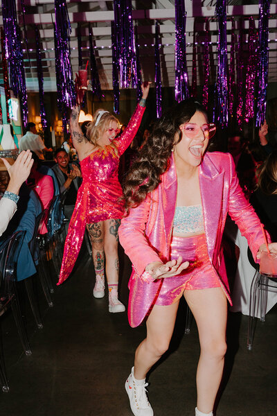 LGBTQ+ wedding couple dancing at the Fig House in Los Angeles California with bright pink sequin clothes 