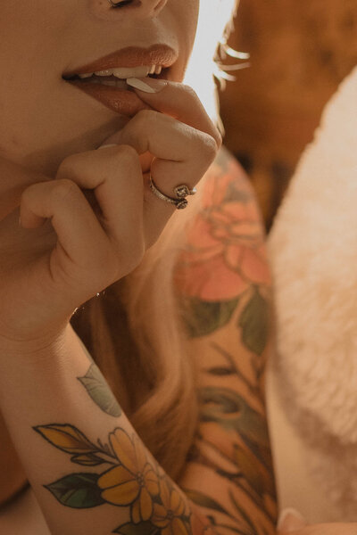 tattooed woman biting her lower lip