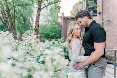 Deven and Ells next to white flowers in Uptown Charlotte