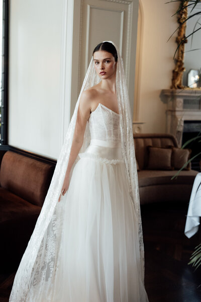 black and white image bride wearing strapless satin wedding dress with long train