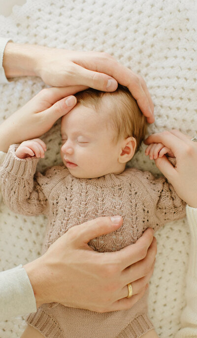 Captured by Tevi hardy, San Francisco newborn photographer - newborn sleeping with the parent's hands around it.