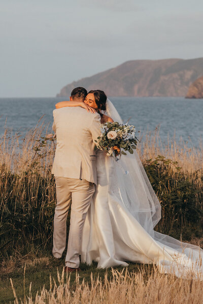 couple hug lovingly by the ocean