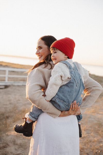 mum toddler piggy back at beach
