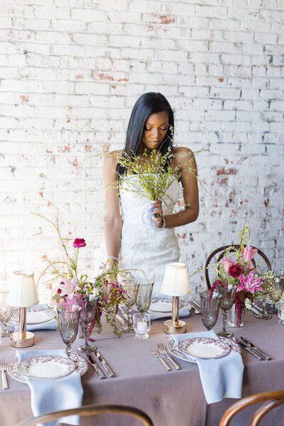 Bride smelling flowers next to tablescape during a Wedding Styled Shoot in Atlanta
