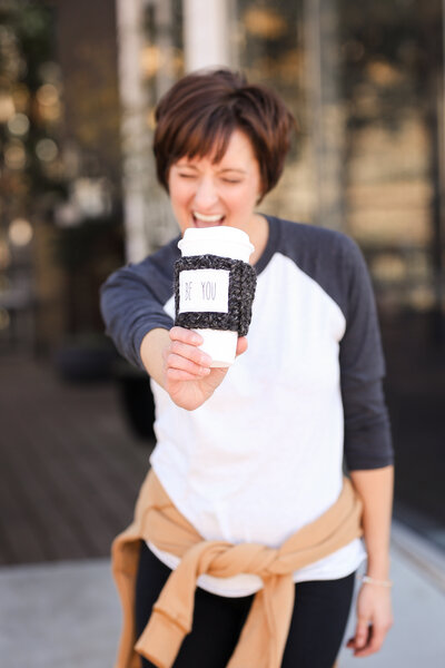 woman smiling holding coffee cup
