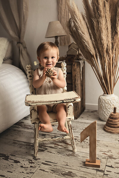 Bébé de 9 mois dans une chaise haute bois blanc pampa
