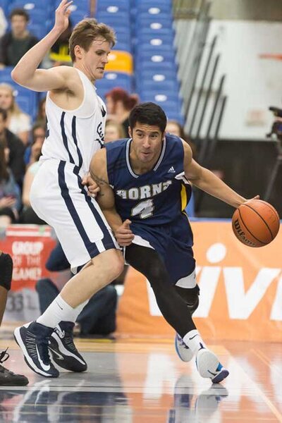 A male basketball athlete running to defend a ball, supported by a custom graphic knee brace, The Elite, designed to provide support for injured ligaments.