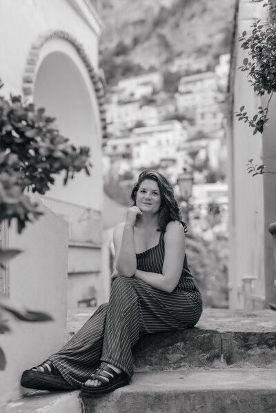 Female sits on steps by olive tree in Positano, Amalfi Coast