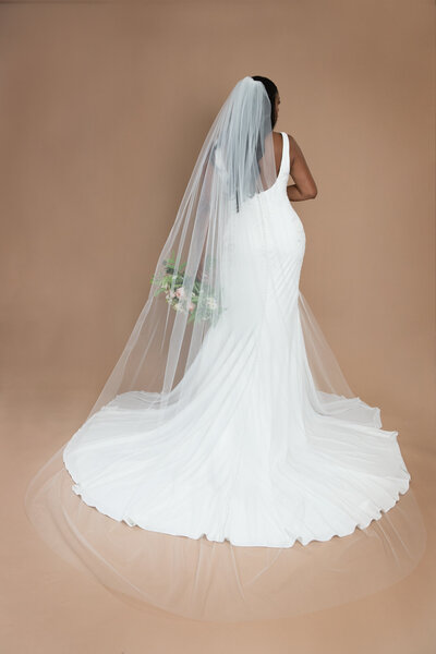 Bride wearing a cathedral length veil and holding a white and blush bouquet